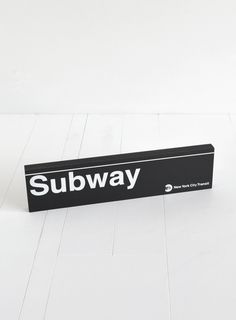 a black subway sign sitting on top of a white floor