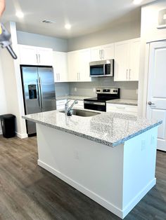 a kitchen with white cabinets and granite counter tops