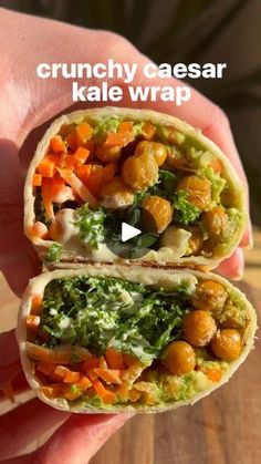 a hand holding a wrap filled with vegetables and chickpeas on top of it