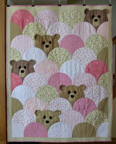 a teddy bear quilt hanging on a wall