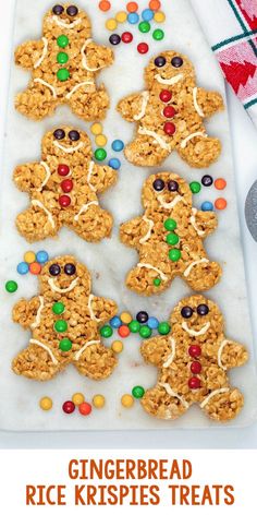 gingerbread rice krispies treats are on a white tray with candy and candies