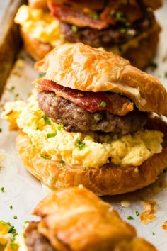 breakfast sandwiches with eggs, bacon and cheese on croissants are ready to be eaten