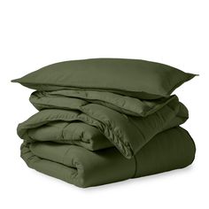 the green sheets and pillows are stacked on top of each other