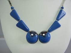 "From the Art Deco era, here's a blue glass bead necklace with mercury glass tube bead side chains.  The two round center beads are accented with silver paint and the entire piece measures 17\" long and has a fish hook style clasp.  Including some earrings that probably did not originally go with the necklace, but the colors are good together. Please see the picture with a coin for size comparison, as items may appear larger than they actually are.  This is necessary to provide accurate details. Vintage Blue Necklaces With Polished Beads, Vintage Blue Polished Beads Jewelry, Blue Beaded Retro Jewelry, Retro Blue Beaded Jewelry, Vintage Blue Necklace With Silver Beads, Vintage Blue Round Beaded Necklace, Vintage Blue Beaded Necklace, Modern Blue Metal Necklaces, Modern Blue Metal Necklace