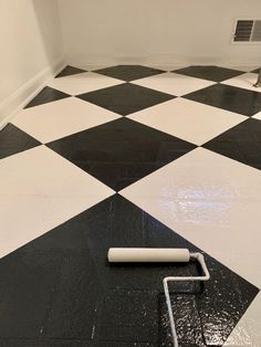 a black and white checkered floor with paint roller