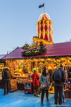 people are standing in front of a christmas market