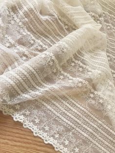 white lace is laying on top of a wooden floor