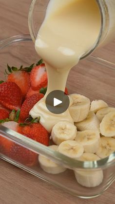 a bowl filled with bananas and strawberries next to a bottle of milk being poured into it