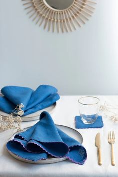 a white table topped with blue napkins and silverware