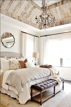 a bedroom with a large bed and chandelier