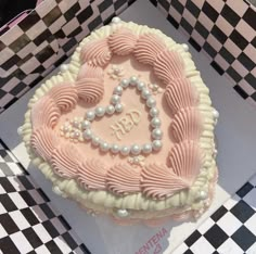 a heart shaped cake sitting on top of a checkered table