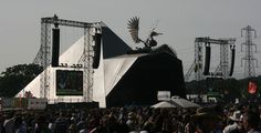 a large group of people standing in front of a stage with an eagle on it