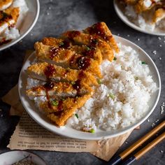 three plates with rice, meat and sauces on them next to chopsticks