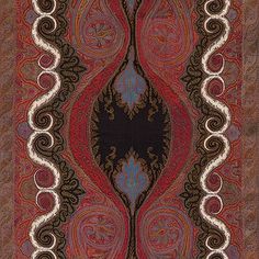 an intricately designed area rug in red, blue and brown with swirls on it