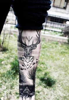 a person with a tattoo on their leg that has a deer and triangle in it