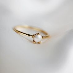 a gold ring with a white pearl on it