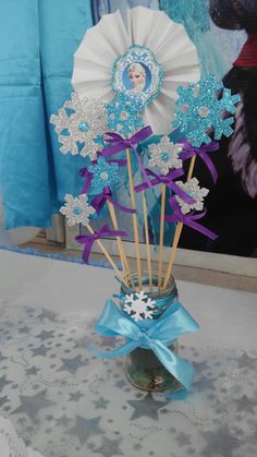 a vase filled with blue and white snowflakes