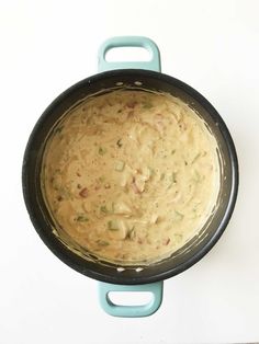 a pot filled with food sitting on top of a counter next to a blue spatula