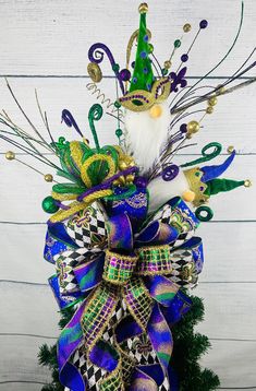 a mardi gras decoration with a mask and feathers on it's head