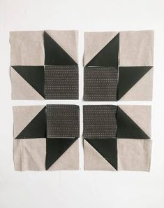 four pieces of black and white fabric are arranged in the shape of an origami