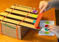 a child is playing with an xylons game on the wooden table at home