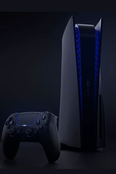 a video game console and controller next to each other on a black background with blue lighting