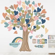 a tree with hearts painted on it and the words you belong here