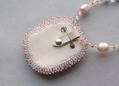 a white beaded necklace with pink beads and a silver clasp on it's end