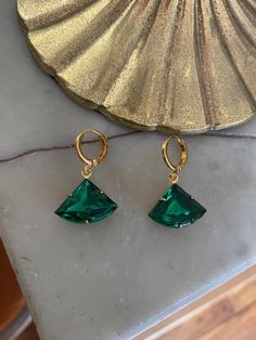 Vintage emerald green glass stone set in a raw brass setting measuring 1.8 cm x 1.3 cm. Hung on gold-plated huggie hoop earrings measuring 1.2 cm x 1.4 cm. Comes in a black velvet pouch. If these are a gift and you would like a box free of charge please mark the order as gift or leave a message at check out. Green Tarnish-resistant Huggie Jewelry, Green Tarnish-resistant Hoop Jewelry, Green Small Hoop Earrings Tarnish Resistant, Small Hoop Green Earrings Tarnish Resistant, Small Hoop Green Tarnish-resistant Earrings, Green Huggie Earrings With Matching Set, Green Emerald Small Hoop Jewelry, Green Tarnish Resistant Small Hoop Earrings, Green Gold-plated Tarnish-resistant Hoop Earrings