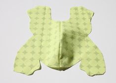 a baby bib made out of yellow material with circles on it's back