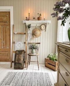 a room filled with lots of furniture and flowers on top of a shelf next to a door