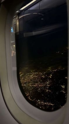 an airplane window looking out at the city lights