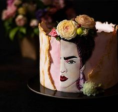 a close up of a cake on a plate with flowers in the top and an elvis presley face painted on it