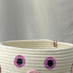 a white basket with pink and black eyes on it