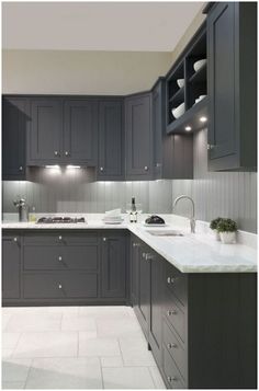 a kitchen with gray cabinets and white counter tops