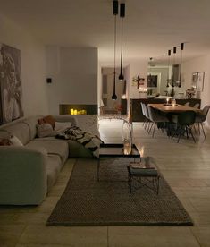 a living room filled with furniture next to a dining room table and two couches