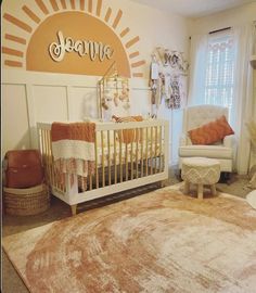 a baby's room with a sun theme on the wall and a white crib