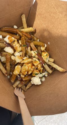 french fries with nuts and cheese in a cardboard box