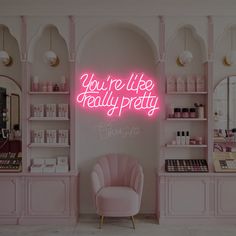 a pink chair sitting in front of a shelf filled with cosmetics