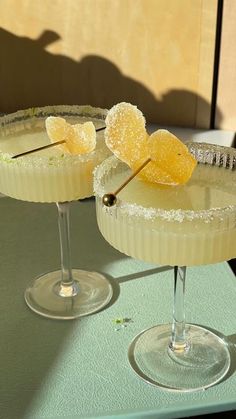 two margaritas sitting on top of a table next to each other