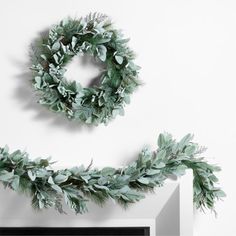 two wreaths are hanging on the wall next to a fireplace