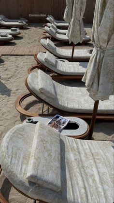 lounge chairs and umbrellas are lined up on the beach