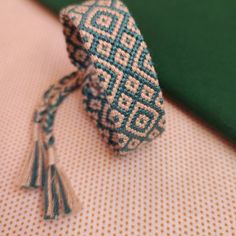 a blue and white tie sitting on top of a green tablecloth next to a book