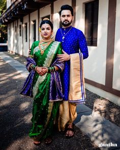 a man and woman standing next to each other in front of a building with trees