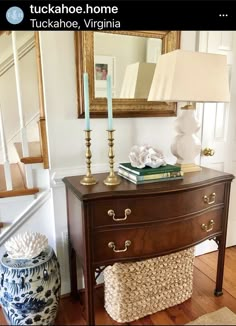 a wooden dresser sitting next to a stair case with a lamp on top of it