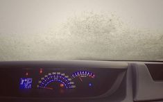 the dashboard of a car with snow on the windshield