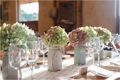 there are many vases with flowers in them on the table at this wedding reception