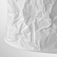 a white lamp shade with torn paper on it