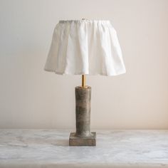 a lamp that is sitting on top of a table in front of a white wall