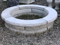 an outdoor fire pit surrounded by cement planters